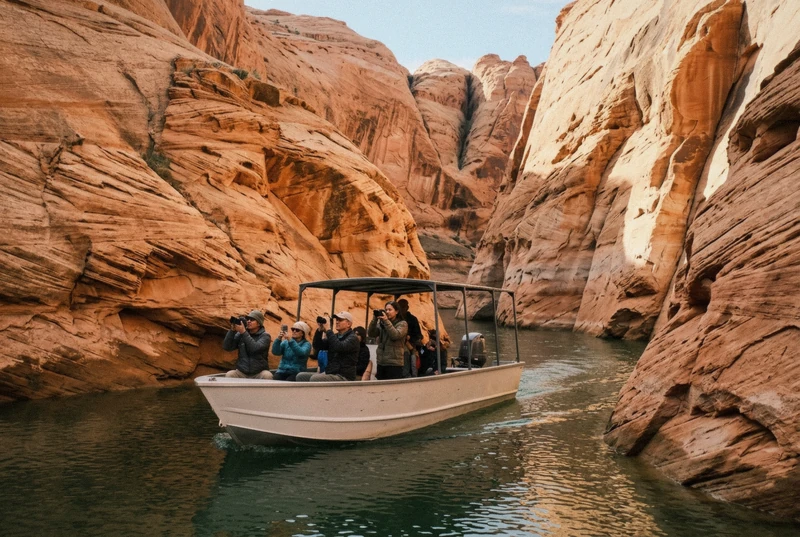 Small tour boat gliding between sandstone walls of Antelope Canyon on an Arizona photoshoot boat tour at Lake Powell