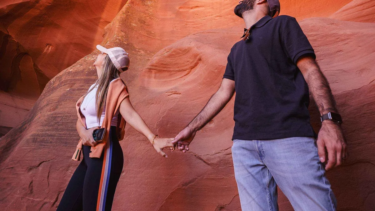 Couple posing between glowing sandstone curves of Antelope Canyon on a private Arizona photoshoot