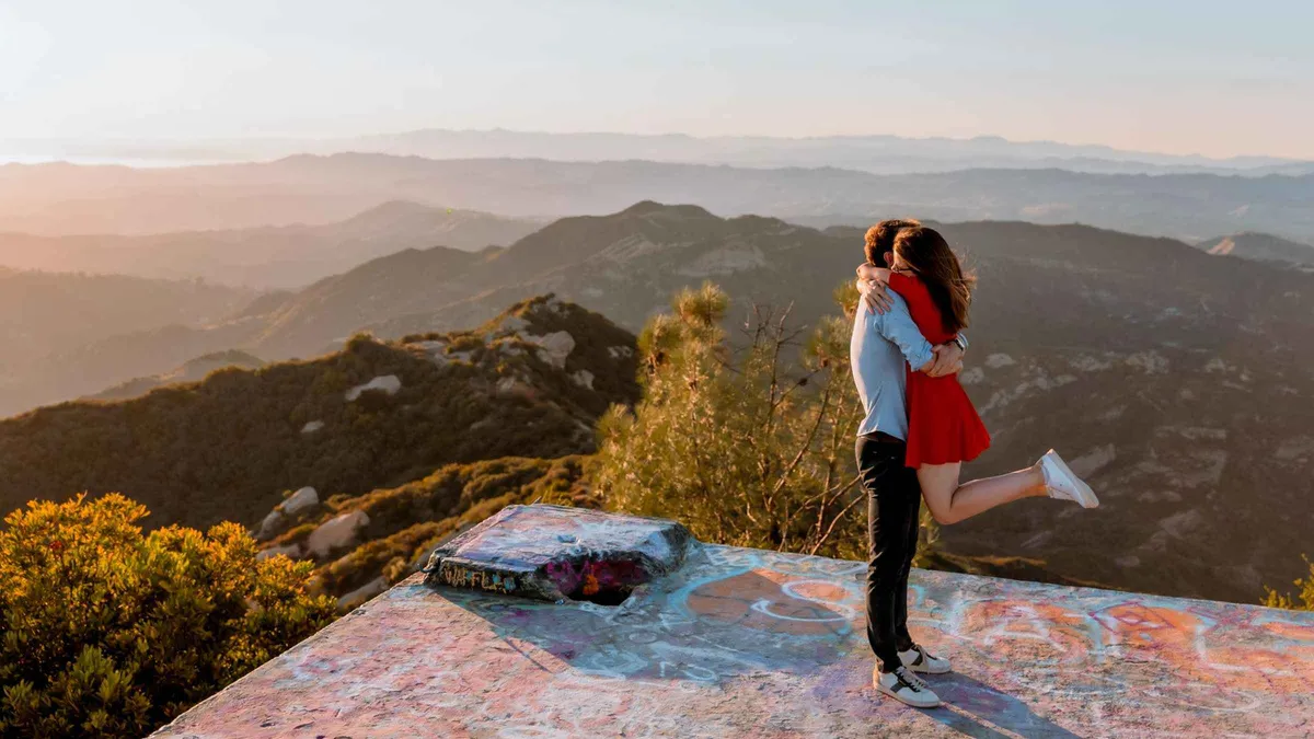 Couple lifted mid-embrace at a mountain overlook at golden hour on a Phoenix Arizona vacation photoshoot
